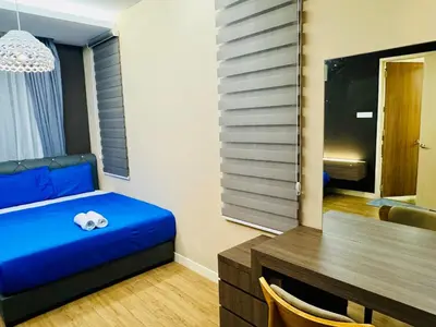 a small room with a blue bed and a desk at Elegant20PaxVilla Perfect Location NearBeachMarket in Batu Ferringhi