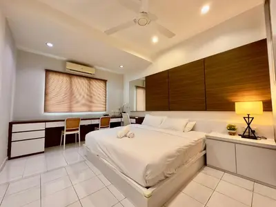 a bedroom with a large bed and a desk and a table at Cozy Homestay in Karpal Singh by 3C in George Town