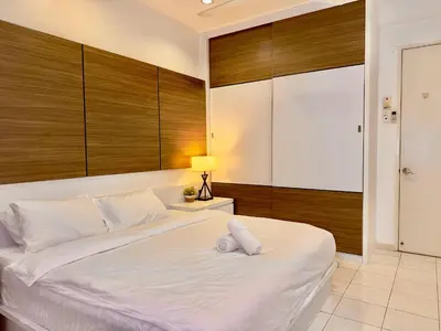 a bedroom with a large white bed with wooden walls at Cozy Homestay in Karpal Singh by 3C in George Town