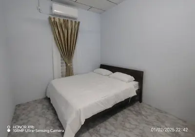 a bedroom with a white bed and a window at Homestay Zainab Sg Dua Mslim With 100mbps Wifi in Kepala Batas