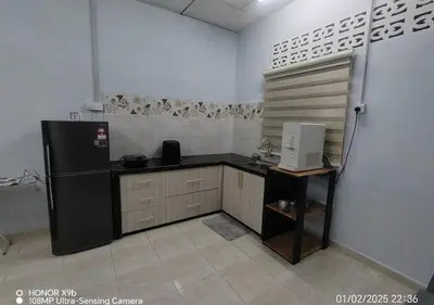 a kitchen with a black refrigerator in a room at Homestay Zainab Sg Dua Mslim With 100mbps Wifi in Kepala Batas