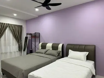 two beds in a room with a purple wall at Forever Green cameron in Brinchang