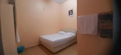 a small bedroom with a white bed in a room at Wonderful Motel in Taiping