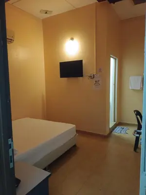 a room with a bed and a tv on the wall at Wonderful Motel in Taiping