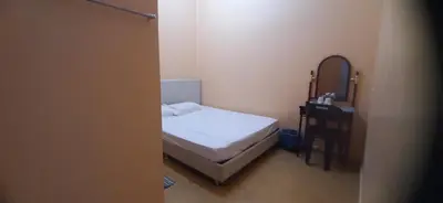 a small bedroom with a bed and a desk at Wonderful Motel in Taiping