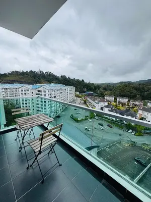 a balcony with a table and chairs on a building at AYAAN PENTHOUSE at QUINTET 5 BED ROOM & ROOFTOP SKY DINING in Tanah Rata