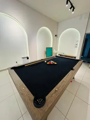 a pool table in a room with three arches at AYAAN SNOOKERS HOUSE at QUINTET FREE PARKING and NETFLIX in Tanah Rata