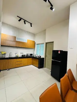 a large kitchen with a black refrigerator and cabinets at AYAAN SNOOKERS HOUSE at QUINTET FREE PARKING and NETFLIX in Tanah Rata