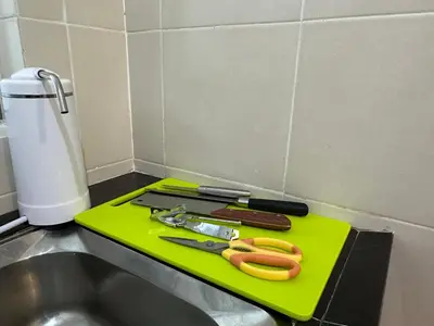 a green cutting board with scissors on top of a sink at Chillrex Homestay Just come over Chill & Relax in Brinchang