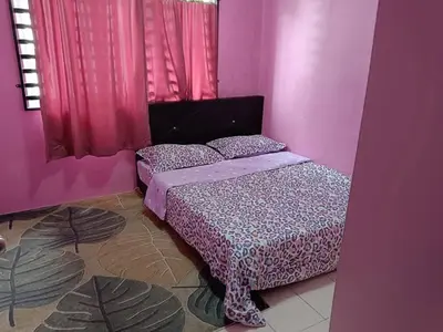 a bedroom with a bed in a pink room at Zaca's Rents in Kampong Duson Gilap