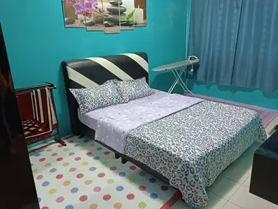 a bedroom with a bed and a blue wall at Zaca's Rents in Kampong Duson Gilap