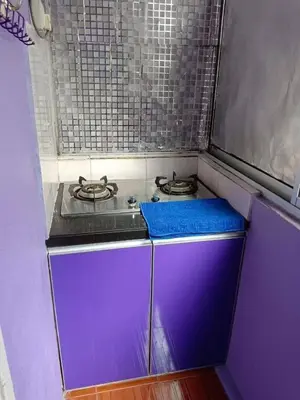 a kitchen with a purple counter with a stove at Zaca's Rents in Kampong Duson Gilap