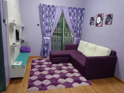 a living room with a purple couch and a purple rug at Zaca's Rents in Kampong Duson Gilap