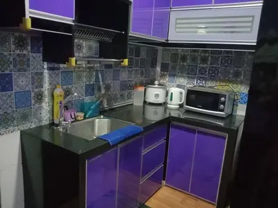 a purple kitchen with a sink and a microwave at Zaca's Rents in Kampong Duson Gilap