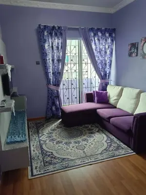 a living room with a purple couch and a window at Zaca's Rents in Kampong Duson Gilap