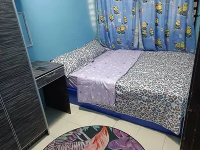 a small bedroom with a bed and a blue wall at Zaca's Rents in Kampong Duson Gilap