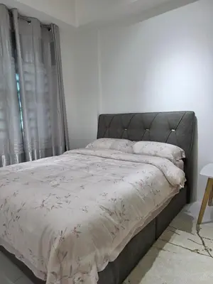 a bed in a white room with a bedspread on it at Nature Beauty Homestay in Seri Iskandar