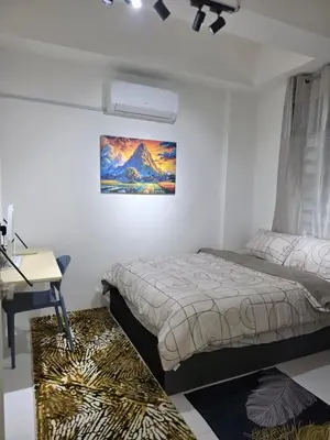 a bedroom with a bed and a desk and a laptop at Nature Beauty Homestay in Seri Iskandar