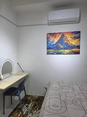 a bedroom with a desk and a painting on the wall at Nature Beauty Homestay in Seri Iskandar