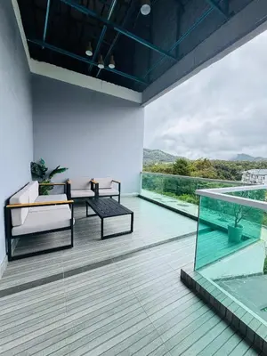 a balcony with a table and chairs and a large window at AYAAN PENTHOUSE at QUINTET ROOFTOP BBQ AND DINING with Mini Snookers in Tanah Rata
