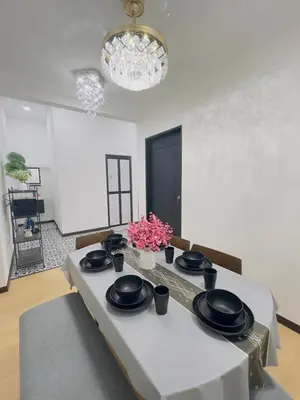 a white room with a table with black plates and flowers at 3Bedroom Landed Cozy Home Ipoh Netflix in Ipoh