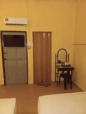 a room with a door and a table with a chair at Wonderful Motel in Taiping