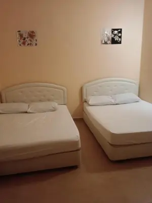 two beds sitting next to each other in a room at Wonderful Motel in Taiping