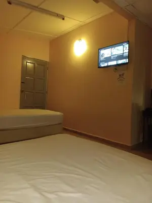 a bedroom with a bed and a television on the wall at Wonderful Motel in Taiping