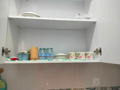 a white shelf with plates and dishes on it at VS Homestay in Ipoh