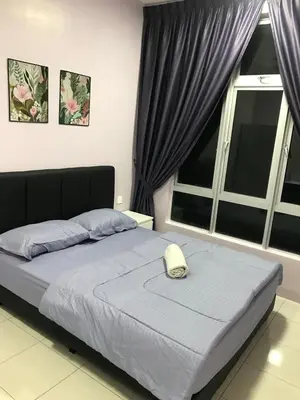 a bedroom with a bed with a phone on it at VS Homestay in Ipoh
