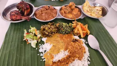 a green plate of food with rice and other foods at Ipoh Town, Anderson Residence in Ipoh