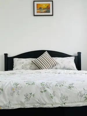 a bed with a white comforter and pillows on it at N&N Modern Apartment in Kampong Padang Meha