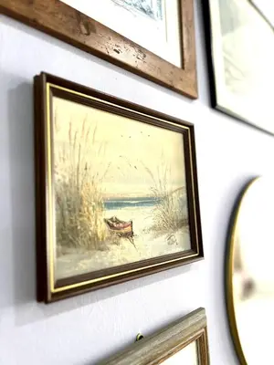 a picture of a painting of a boat on a wall at N&N Modern Apartment in Kampong Padang Meha