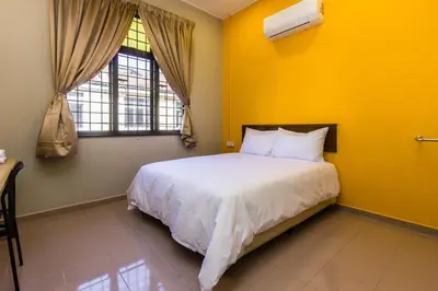 a bedroom with a white bed and a yellow wall at 13-Pax Vacation Retreats in Butterworth near Sunway Carnival in Perai