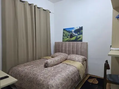 a bedroom with a bed with pillows and curtains at Aqimi Homestay in Seri Iskandar