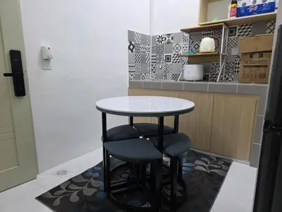 a small kitchen with a table and a stool at Aqimi Homestay in Seri Iskandar