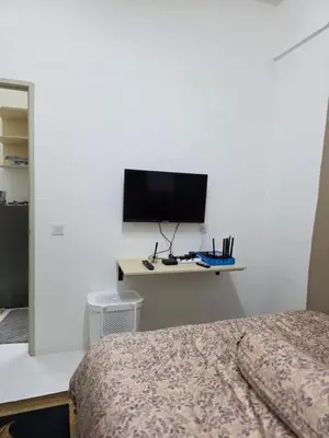 a bedroom with a bed and a tv on a wall at Aqimi Homestay in Seri Iskandar