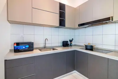 a kitchen with a sink and a tv on a counter at The Sun by Stellar ALV in Bayan Lepas