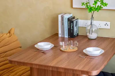 a wooden table with two bowls and glasses on it at The Sun by Stellar ALV in Bayan Lepas