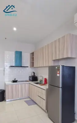 a kitchen with a stainless steel refrigerator and wooden cabinets at Iconic Regency by BNB4U in Bayan Lepas