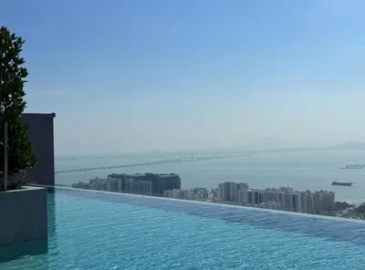 a swimming pool on top of a building with a city at Iconic Regency by BNB4U in Bayan Lepas