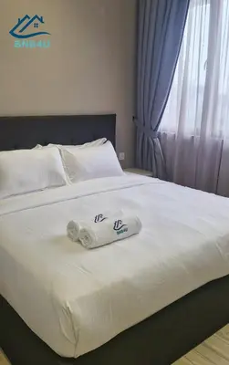 a white bed with two towels on it at Iconic Regency by BNB4U in Bayan Lepas