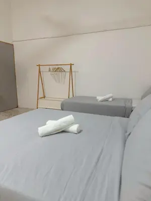 two beds with white towels sitting on top of them at W Home at Jalan Rangoon, George Town Penang in George Town