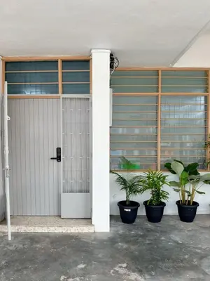 a white garage door with two potted plants at W Home at Jalan Rangoon, George Town Penang in George Town