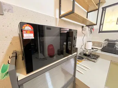 a microwave oven on a wall in a kitchen at \u5b85\u4e00\u8d77 Tonight29 Ipoh City 14Pax SmartTV Netflix 5G in Ipoh