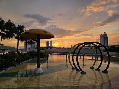 a couple of chairs in a pool with a umbrella at New Metropol 3 Bedrooms Pool View in Bukit Mertajam