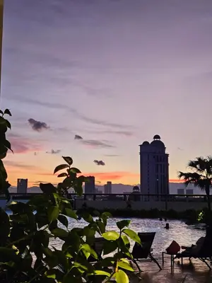 a sunset over a city with a clock tower at New Metropol 3 Bedrooms Pool View in Bukit Mertajam