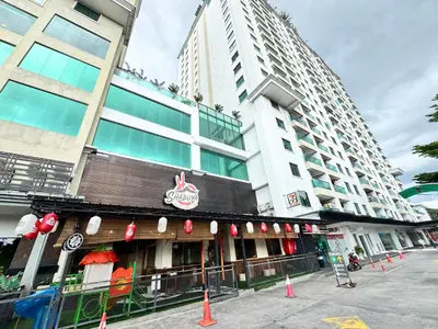 a building with a restaurant with red signs on it at Kinta River Town Suites By IWH in Ipoh