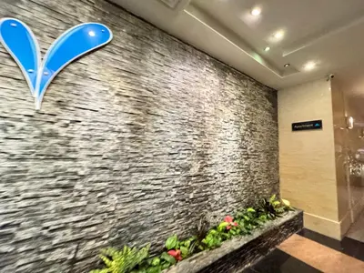 a lobby with a stone wall with a vase on it at Kinta River Town Suites By IWH in Ipoh