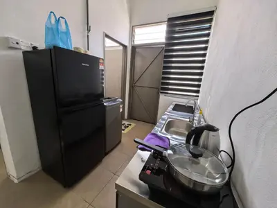 a kitchen with a sink and a microwave at Suite Karangan Near Inokom in Titi Karangan